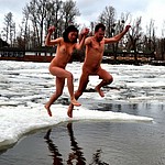 Crazy russians swim in cold water during the winter days. Great tradition of Epiphany religious holiday. See nudists and naturist men and women swmming nude in ice hole